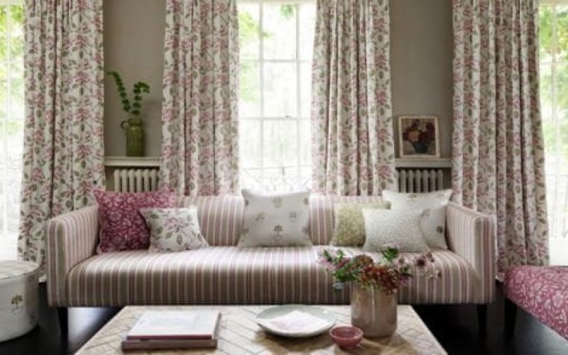 Country cottage style living room with stripey couch and floral curtains
