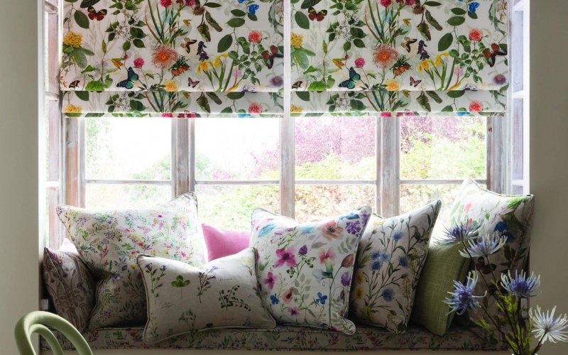 window seat with cushions and colourful blinds