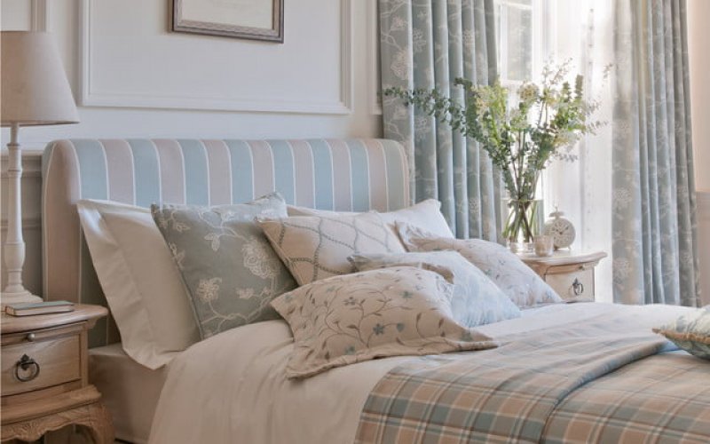 country cottage style bedroom with a thick quilt and curtains